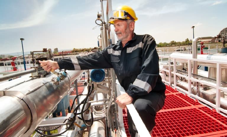 Feldarbeiter neben den großen Rohren