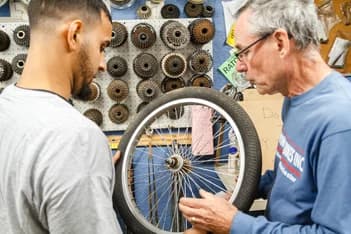 Qualitrol-Freiwillige reparieren ein Fahrrad für eine Gemeindespende
